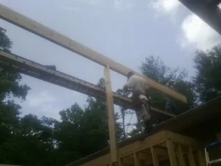 Carpenter setting a ridge beam over a new addition frame — Ice Dam Removal by Roofing Brothers in Fort Wayne