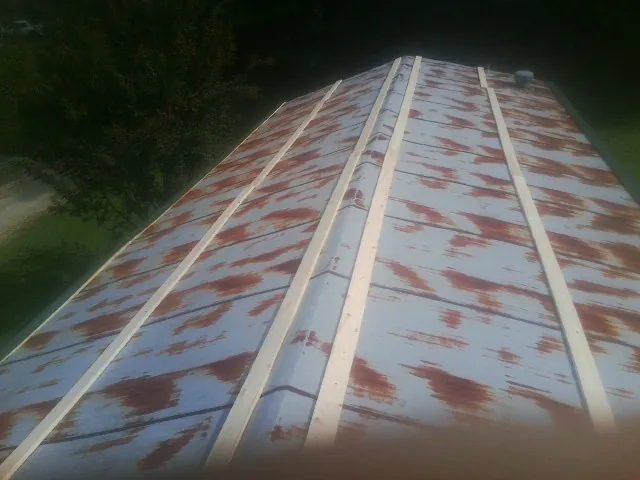 Rusted metal roof panels with new wood purlins before replacement — Storm Damage Roof Repair in Fort Wayne by Roofing Brothers