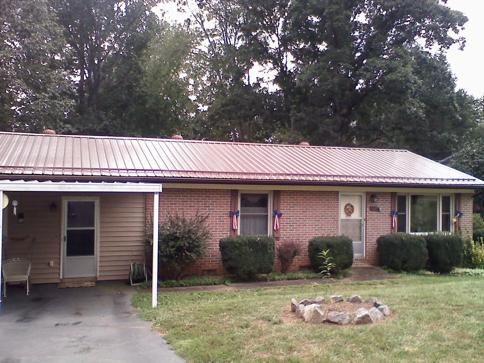 Bronze metal roof and carport on a brick ranch home — Roof Repair work by our crew in Fort Wayne